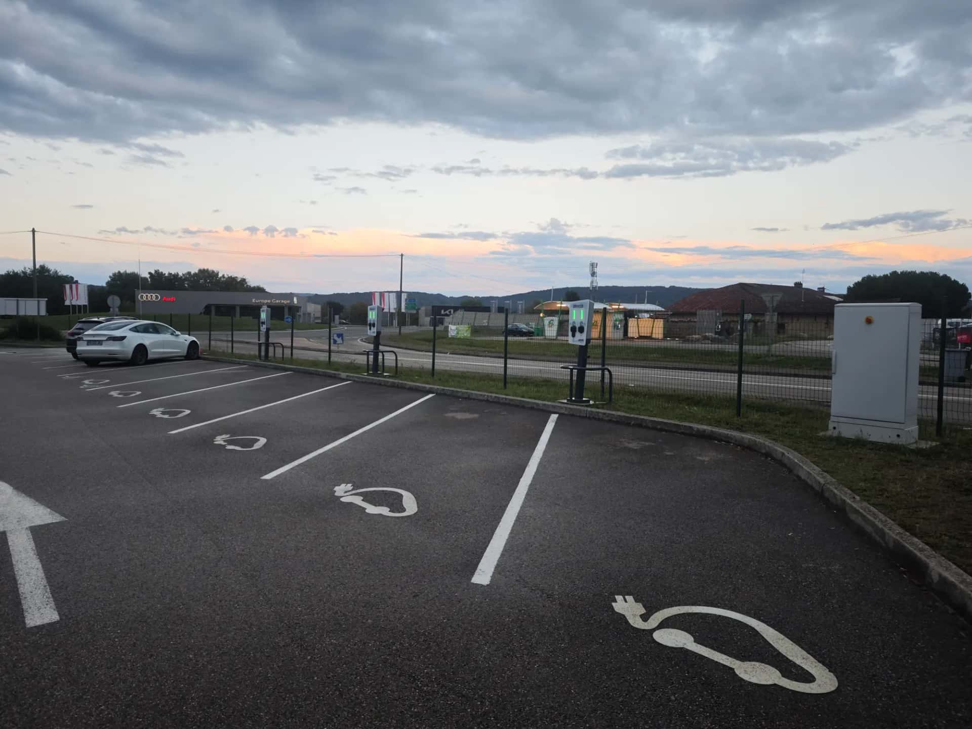 Plusieurs bornes de recharge alignées sur les places d'un parking collectif
