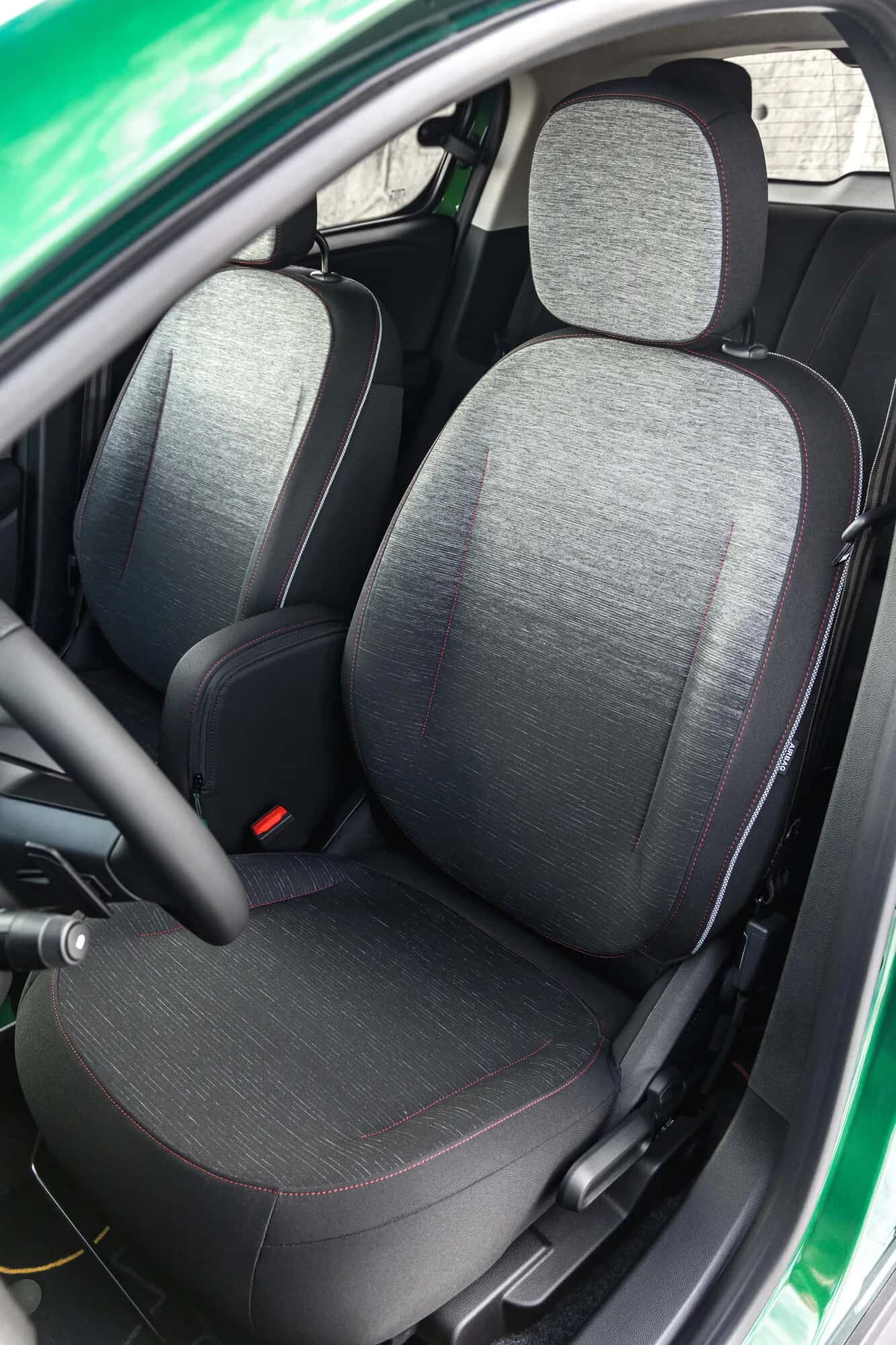 Sièges avant Renault Twingo Techno 2026, tissu gris chiné avec surpiqûres rouges, finition habitacle