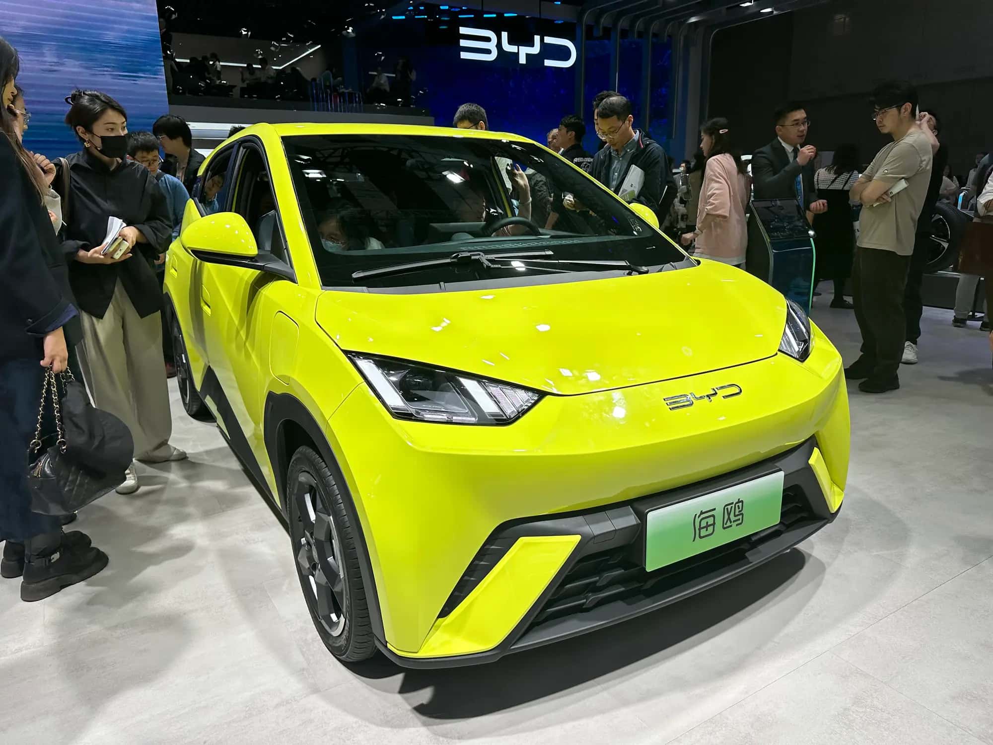 Une citadine électrique BYD jaune exposée sur un stand de salon automobile