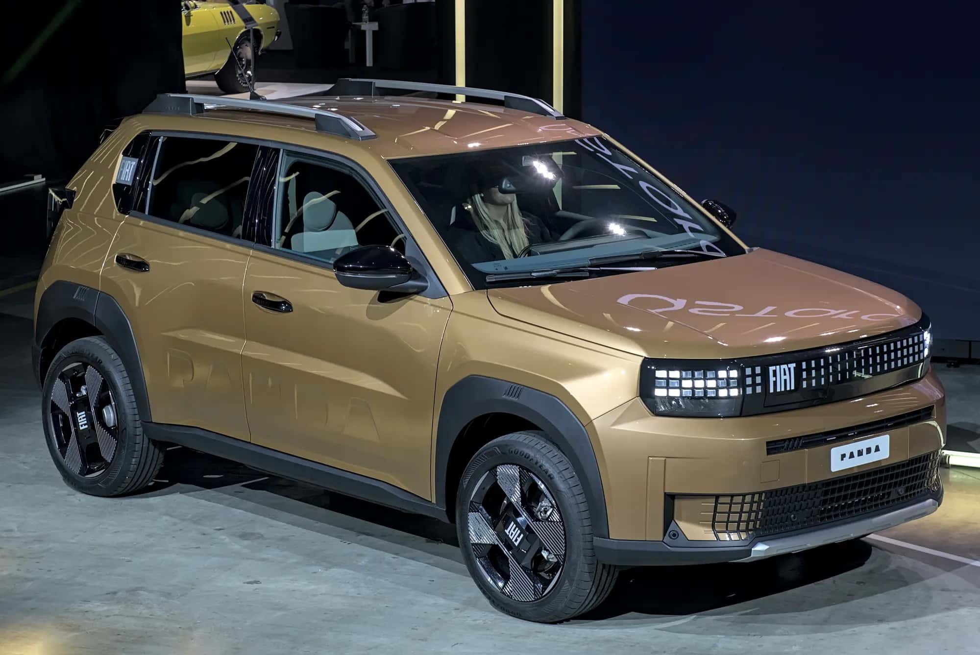 La Fiat Grande Panda électrique bronze vue de trois quarts avant sur un stand