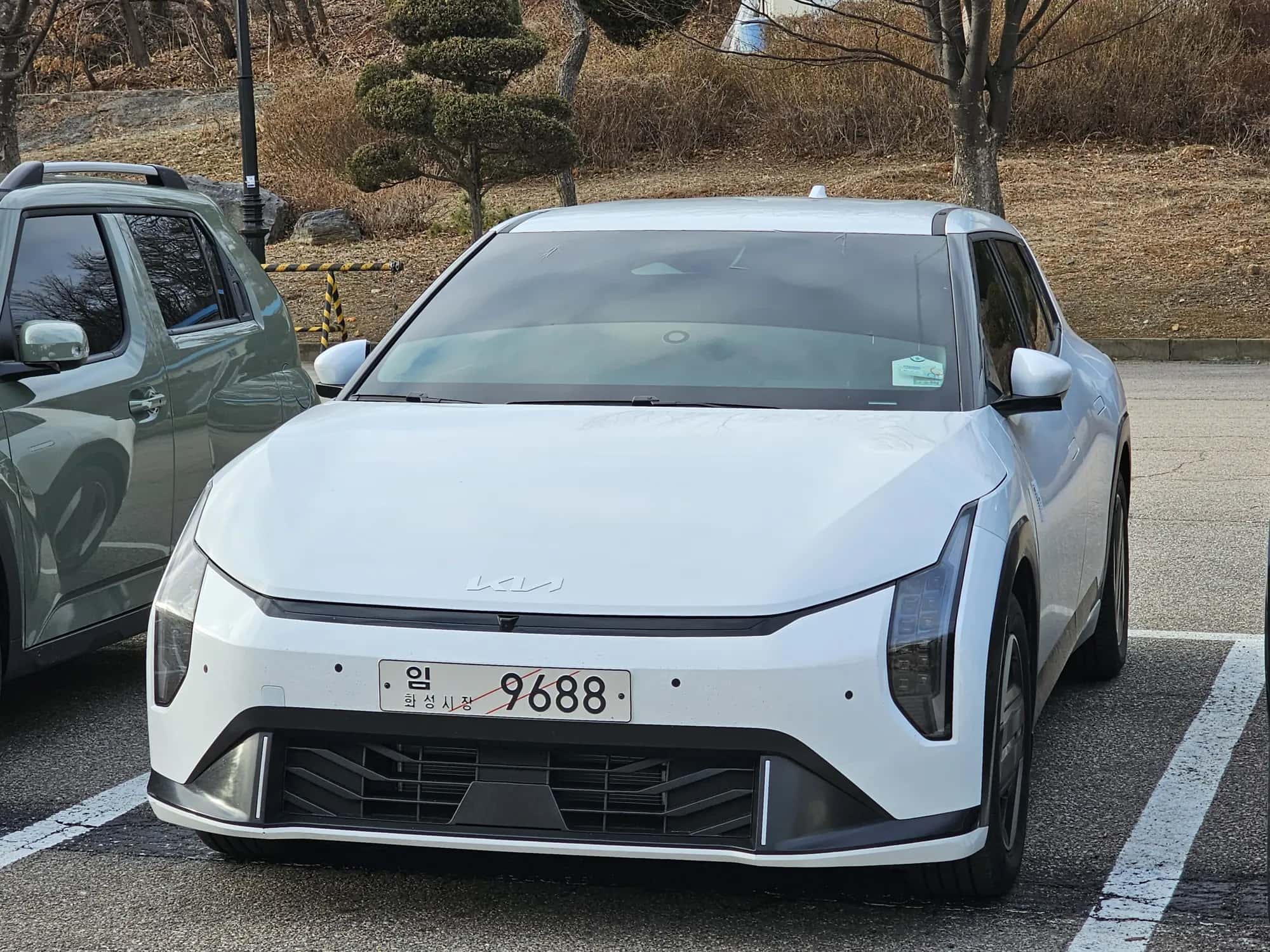 La Kia EV4 blanche vue de trois quarts avant sur un parking