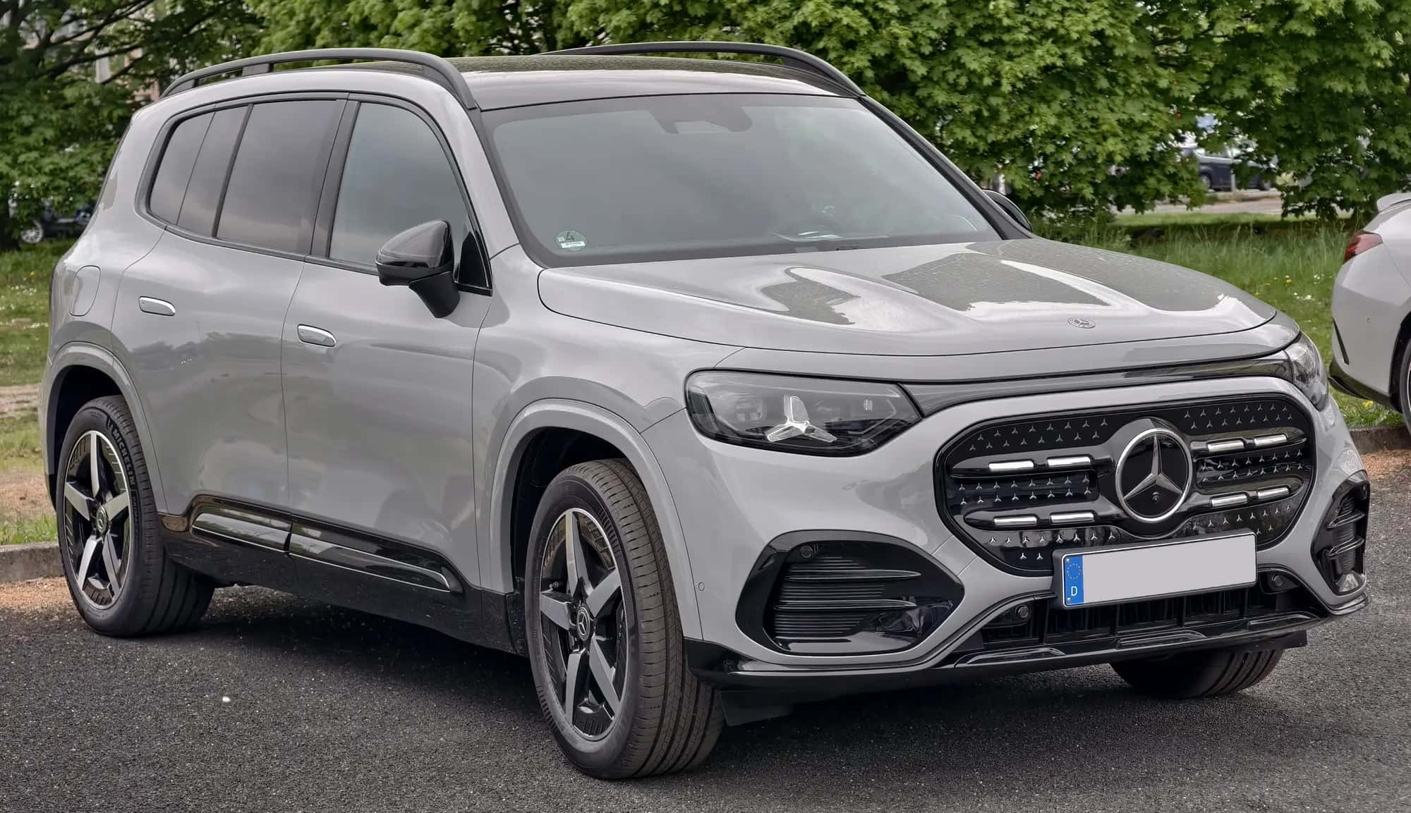 Le Mercedes GLB à technologie EQ gris vu de trois quarts avant, sous les arbres