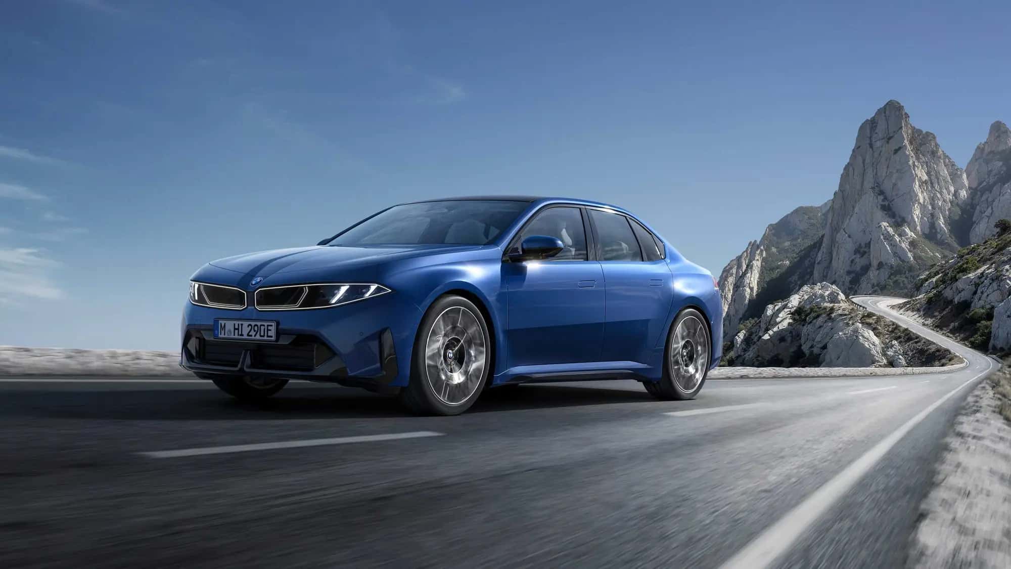 La BMW i3 50 xDrive bleue vue de trois quarts avant sur une route de montagne