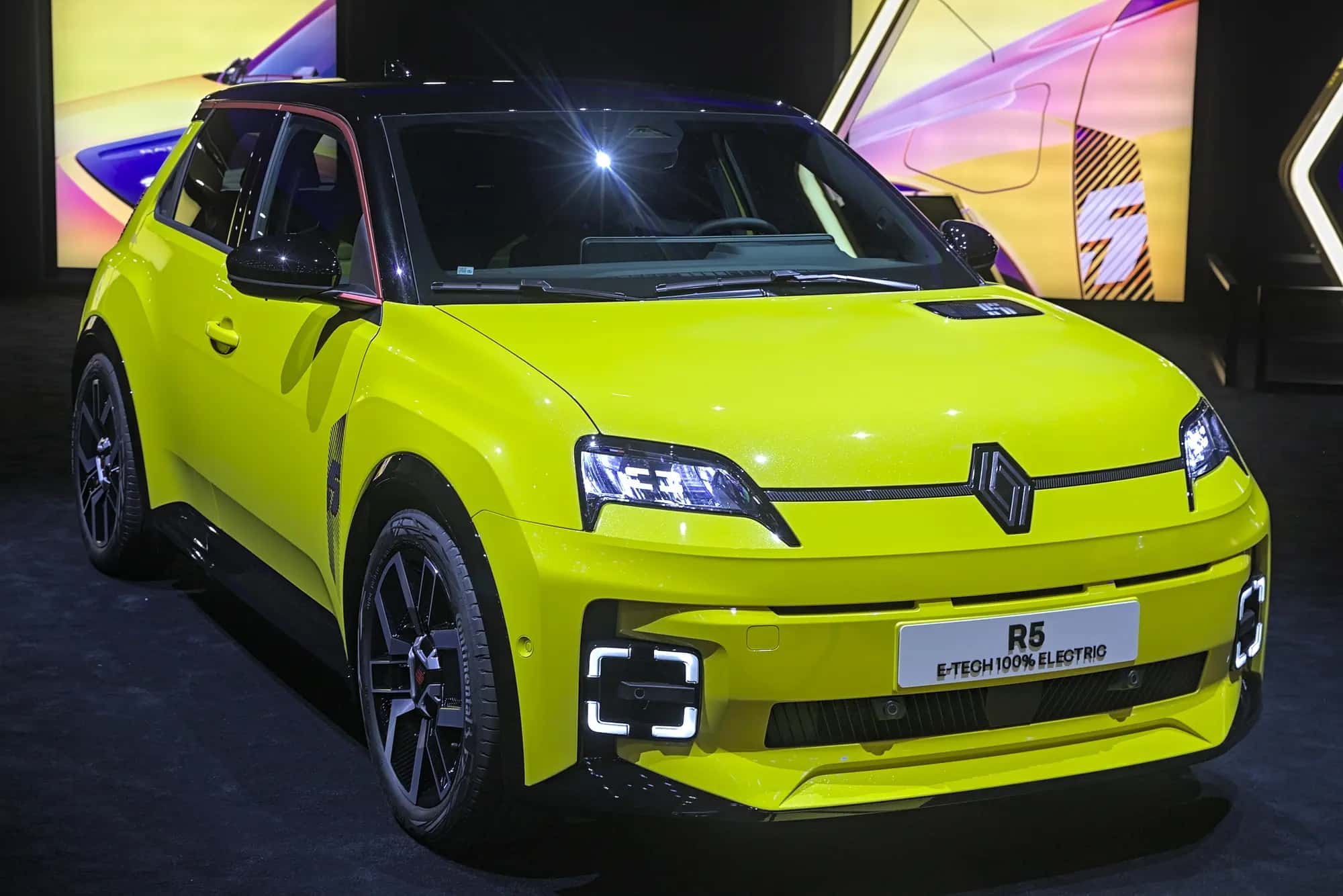 La Renault 5 E-Tech jaune vue de trois quarts avant sur un stand de salon