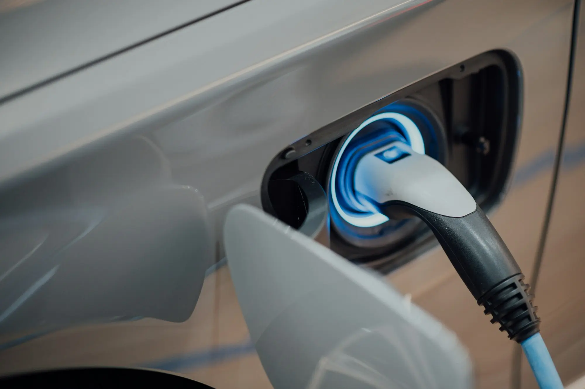 Câble de recharge branché sur la prise bleue d'un véhicule hybride rechargeable