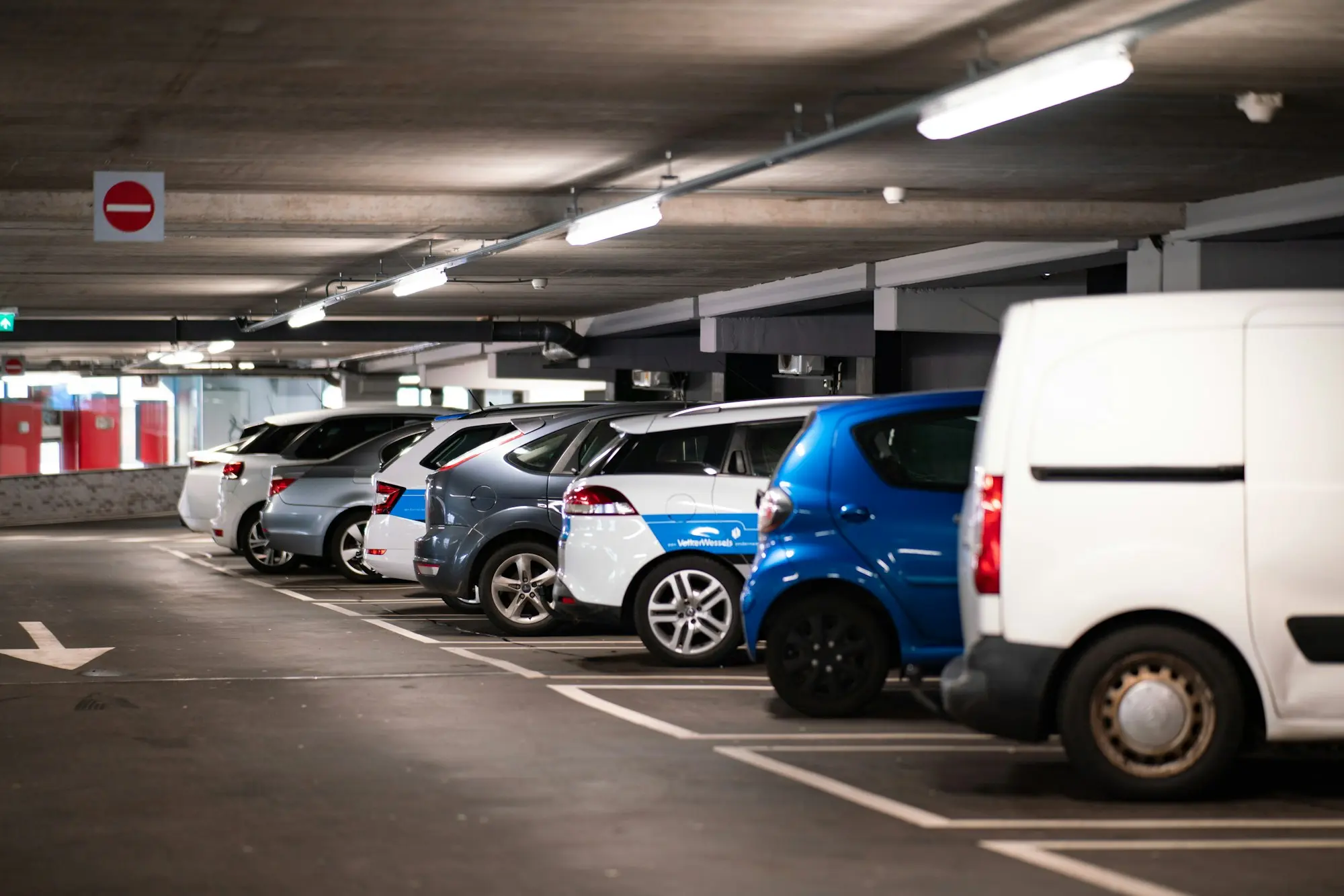 Des véhicules d'entreprise alignés dans un parking couvert