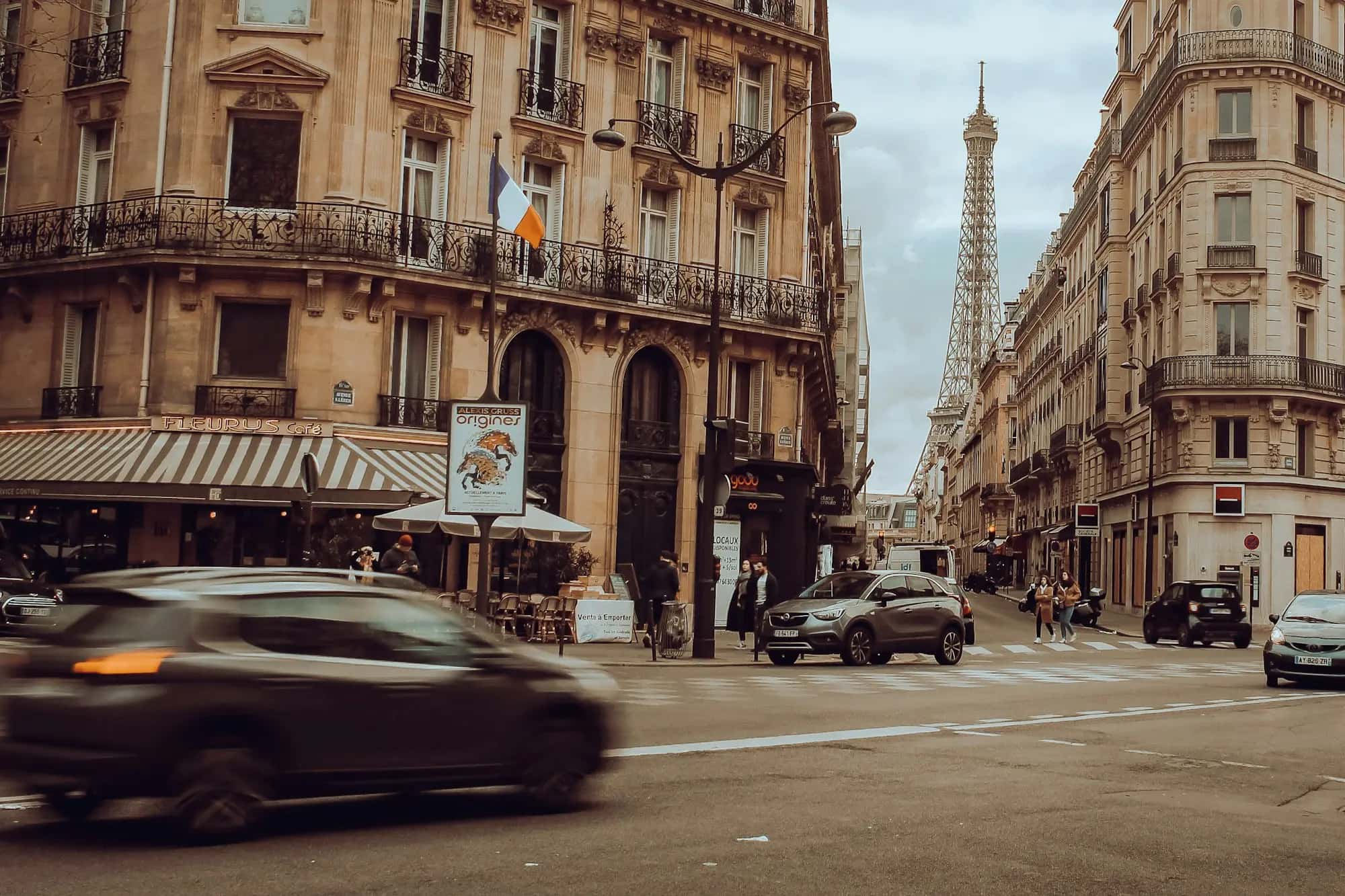 Une voiture en mouvement dans une rue parisienne, la tour Eiffel au fond