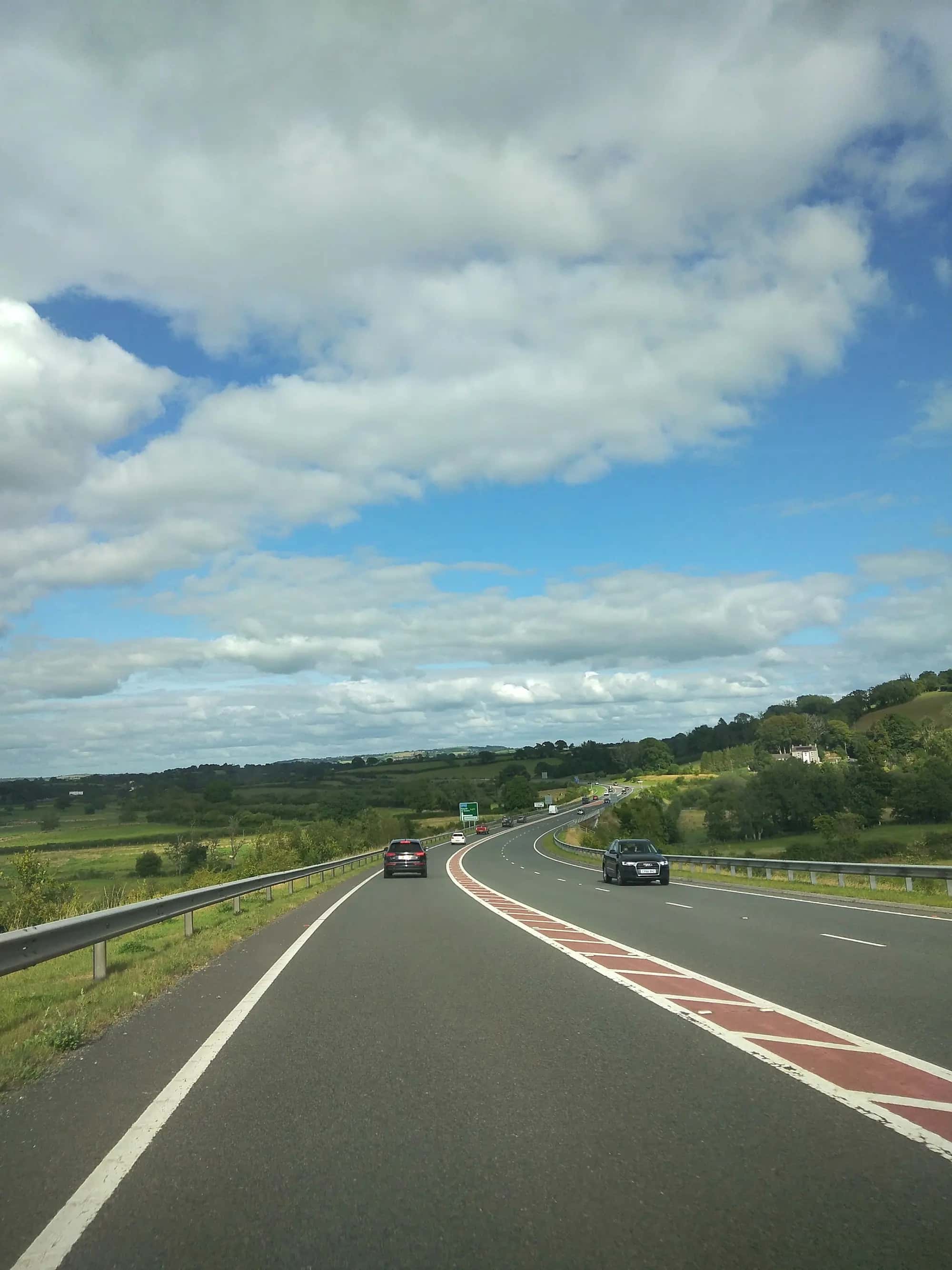 Une autoroute traversant la campagne, deux voitures roulant au loin