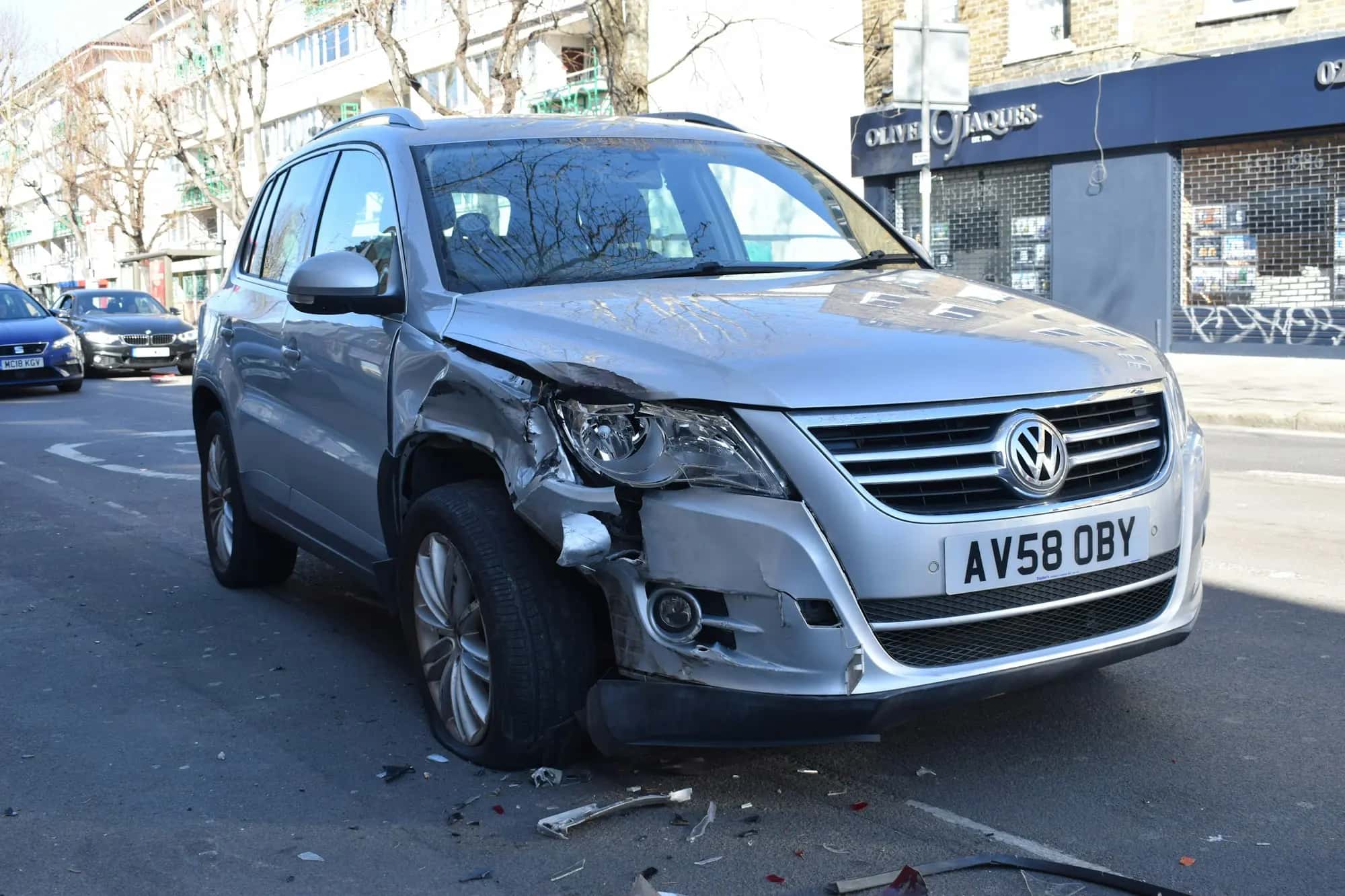 Une voiture grise à l'avant enfoncé, immobilisée sur la chaussée après un choc