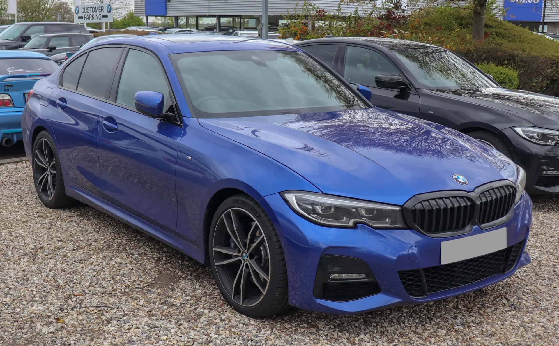 Une berline bleue garée en bord de rue, vue de trois quarts avant