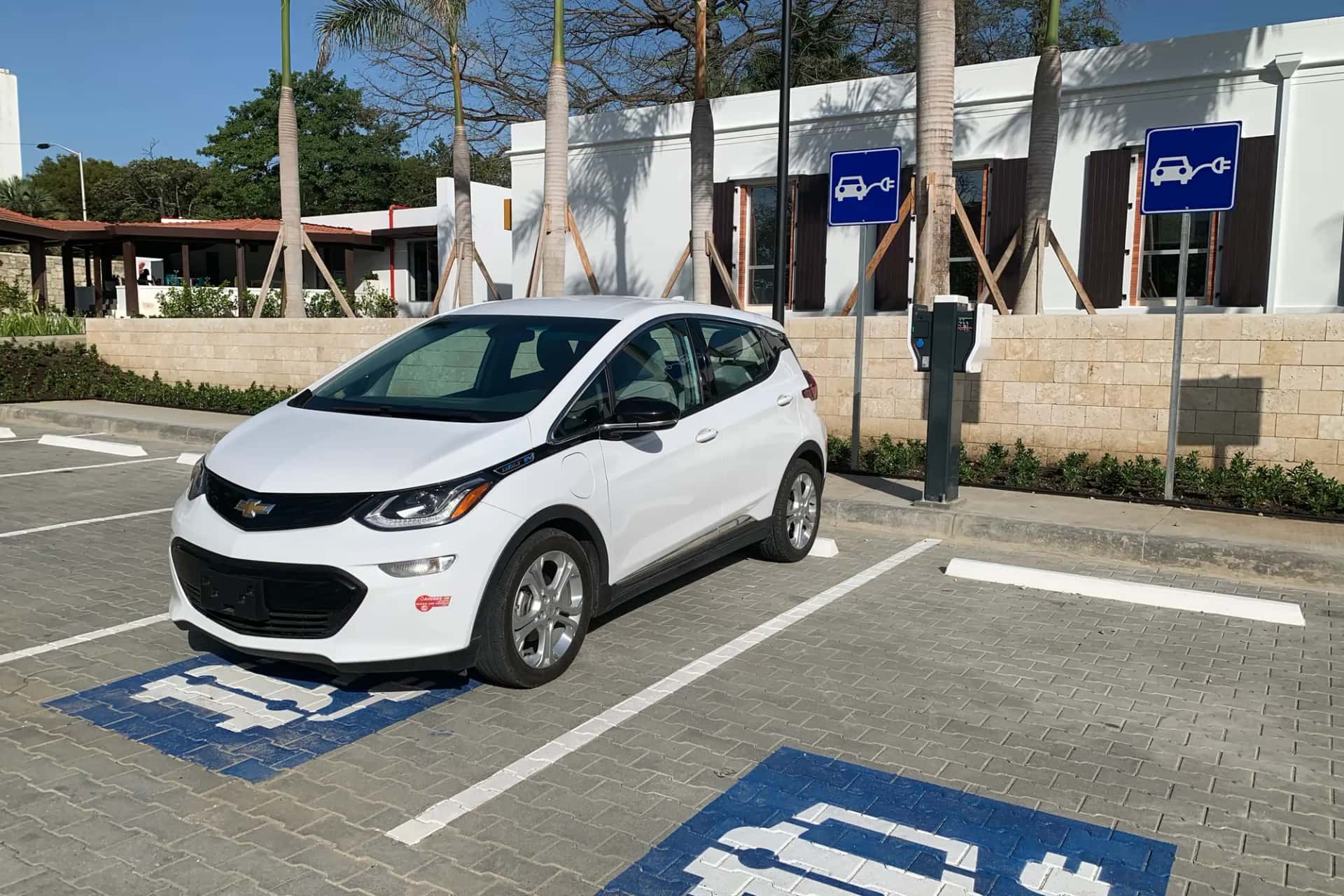 Une voiture électrique blanche stationnée sur une place de recharge réservée