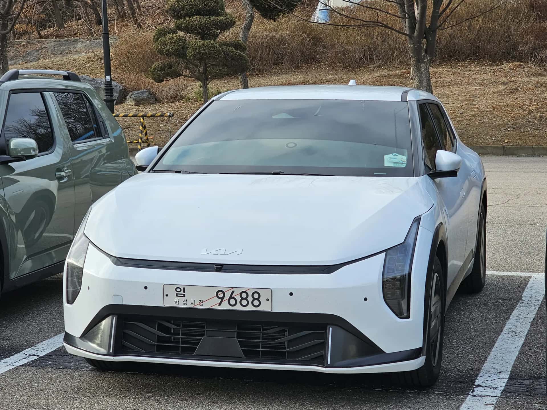 La Kia EV4 blanche vue de trois quarts avant sur un parking
