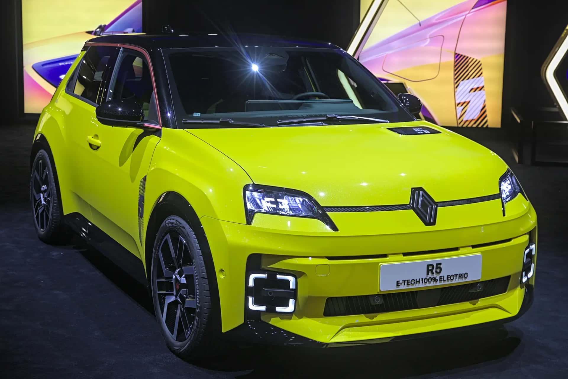 La Renault 5 E-Tech jaune vue de trois quarts avant sur un stand de salon