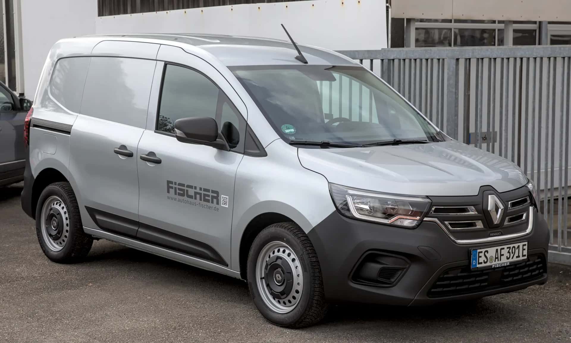 Un fourgon utilitaire électrique gris aux couleurs d'une entreprise, vu de trois quarts avant