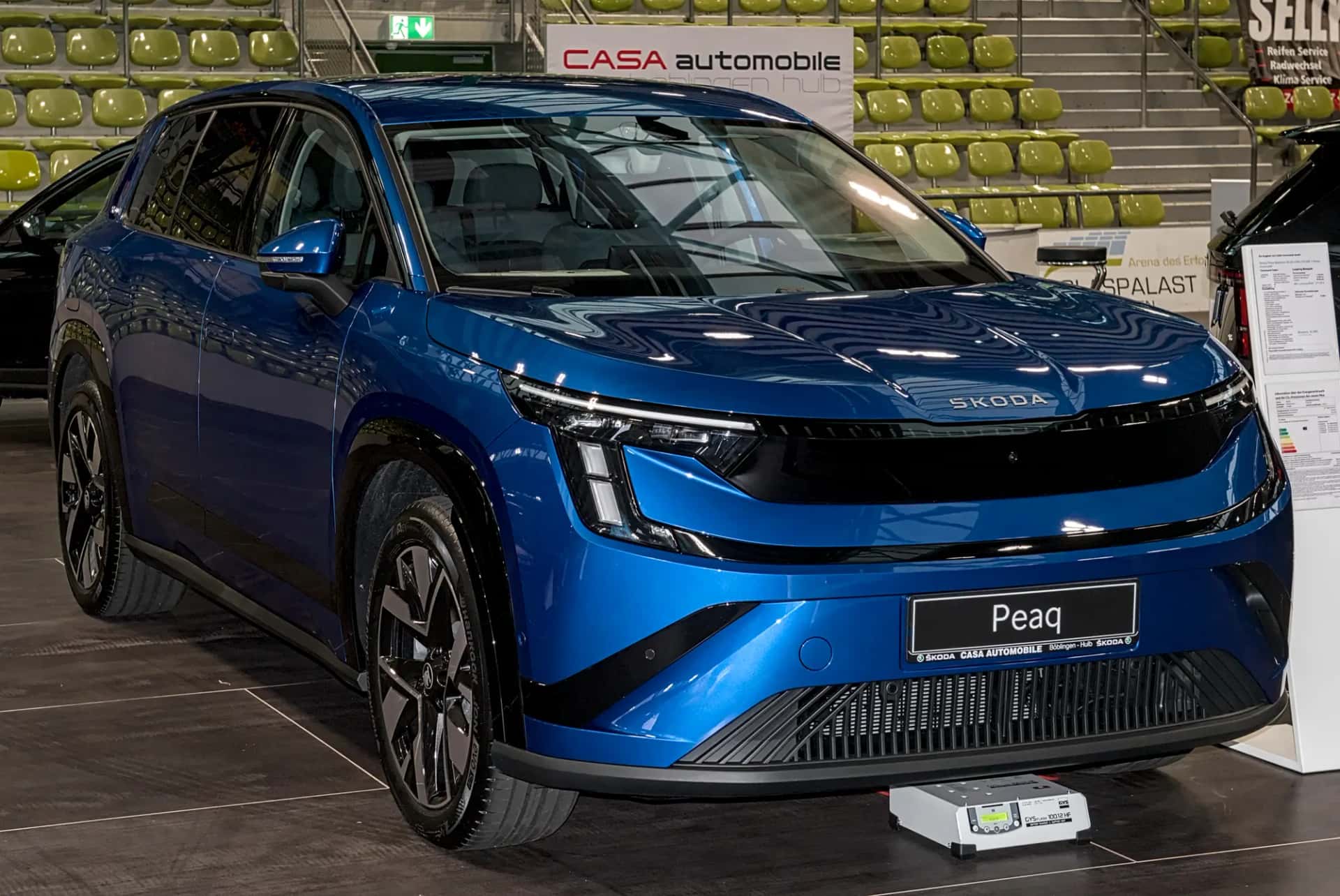 Škoda Peaq bleu vu de trois quarts avant dans un salon automobile, grand SUV électrique à sept places