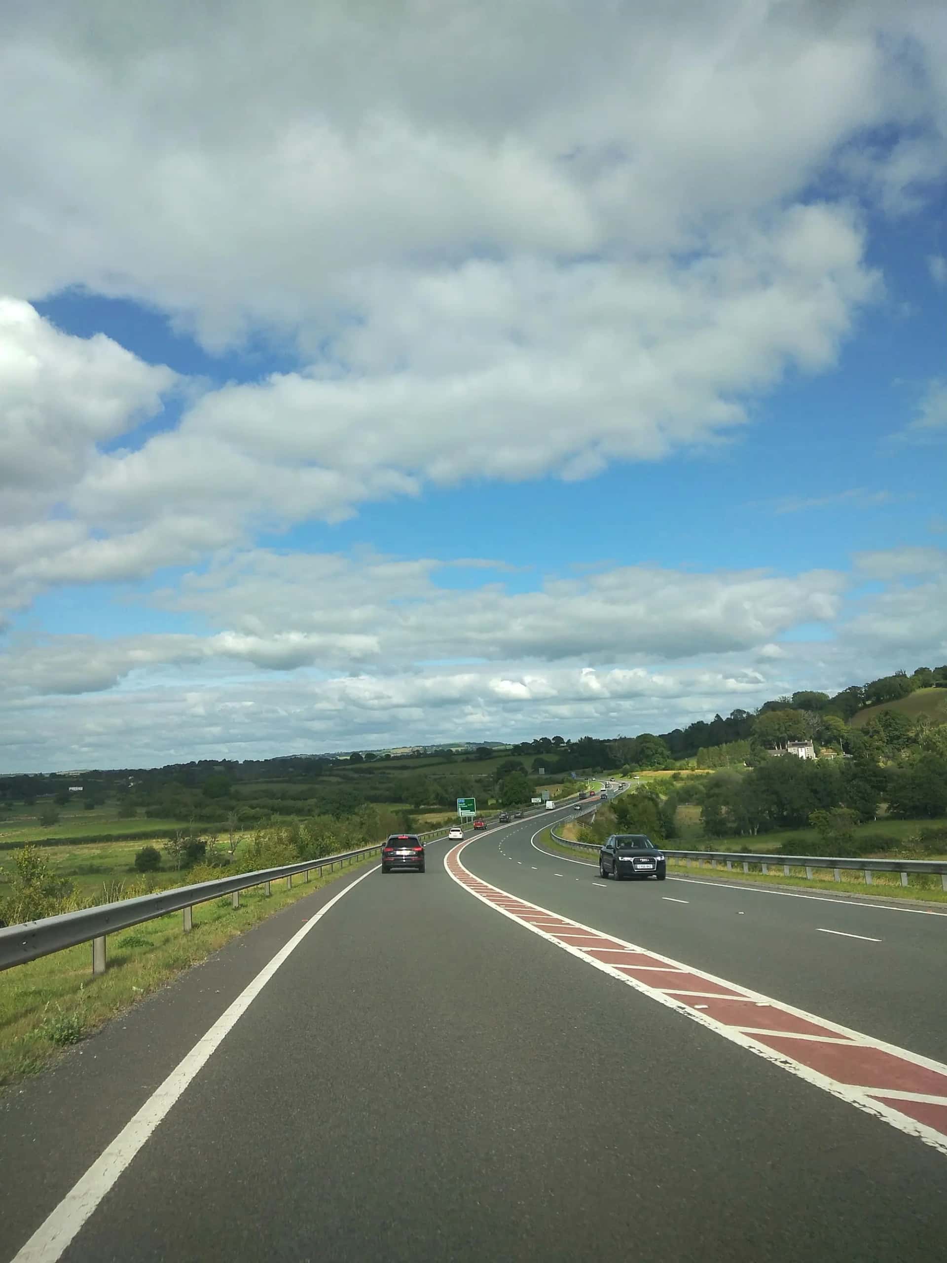 Une autoroute traversant la campagne, deux voitures roulant au loin
